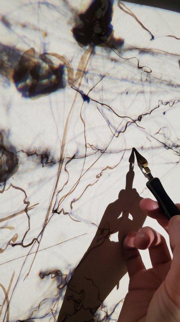 a drawing and projected image with a fountain pen and hand